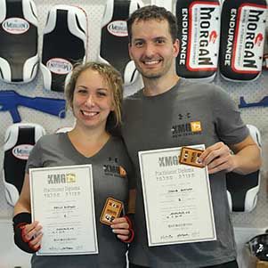 Krav Maga Auckland students Denisa and Jakub holding their KMG diplomas