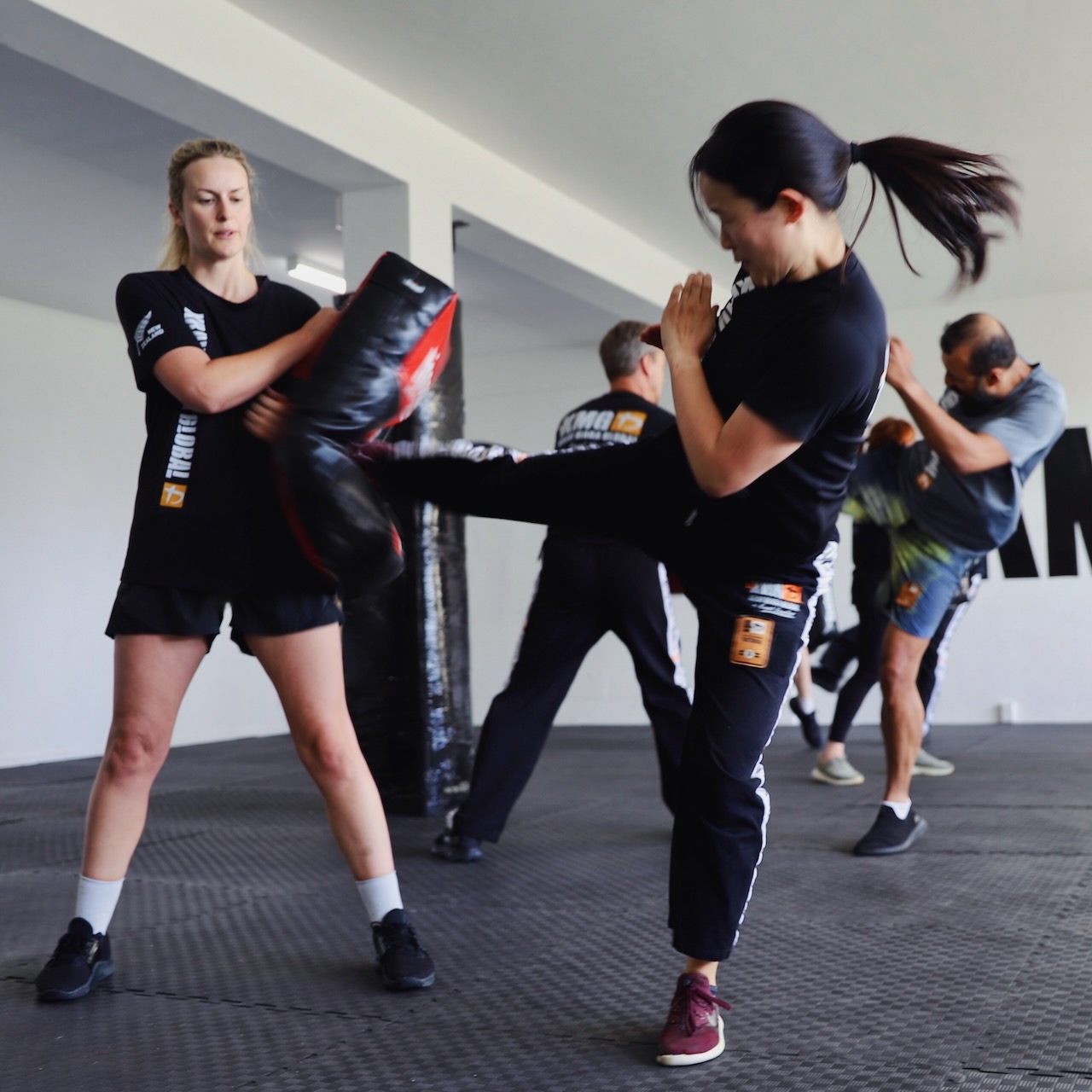 KMG New Zealand students kicking pads — a high-intensity cardio drill that builds both fitness and striking technique
