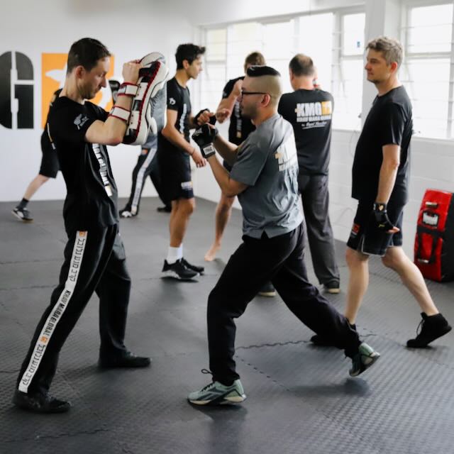 Members drilling in pairs at Krav Maga Auckland — pad work, mid-class, real training at Birkenhead, North Shore