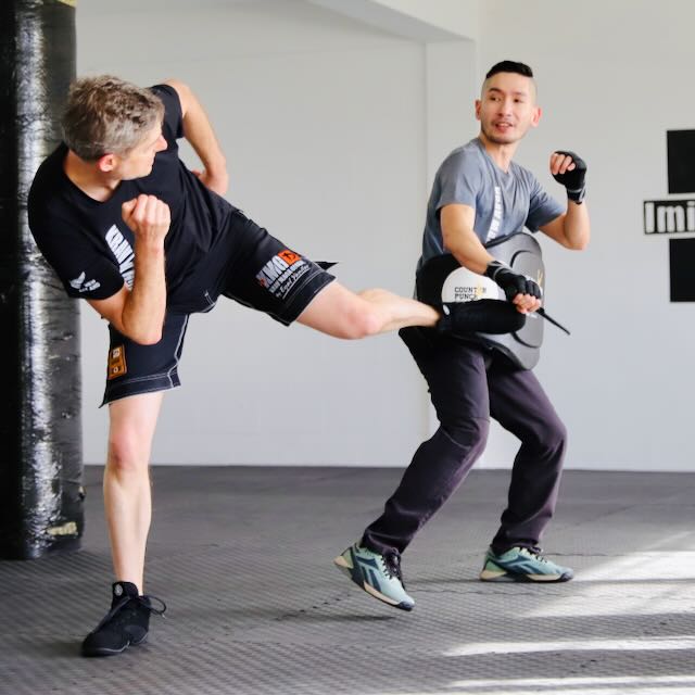 Krav Maga Auckland training a side kick against a knife threat — attacker uses a padded training knife. Not martial arts, not sport — practical self-defence.