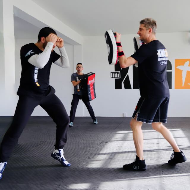 Krav Maga Auckland students drilling strikes on Thai pads during a class on the North Shore