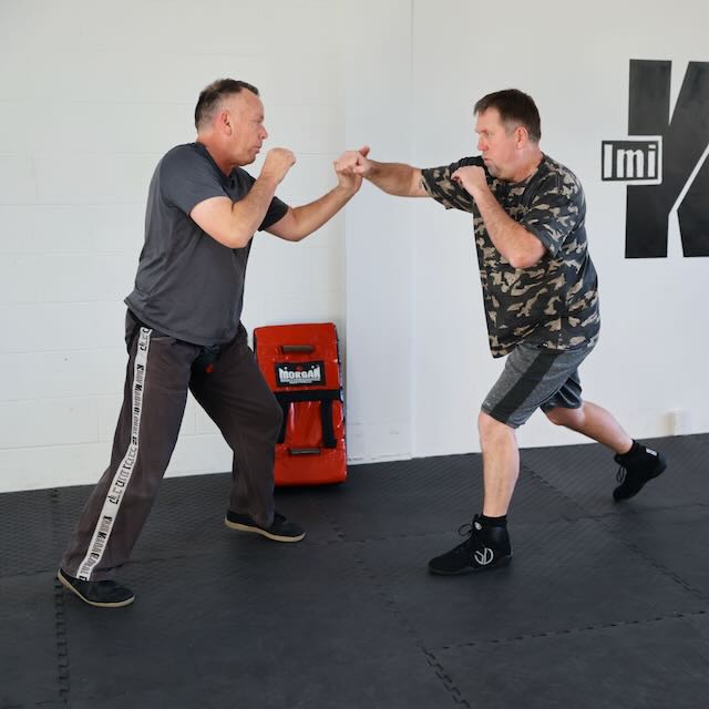 Two adult students pad-sparring during a Krav Maga fitness class at Krav Maga Auckland, North Shore