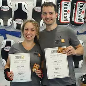 Denisa and Jakub holding their KMG Level 1 diplomas after completing their grading at Krav Maga North Shore, Birkenhead