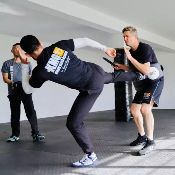 KMG New Zealand student defending against a knife attack with a side kick