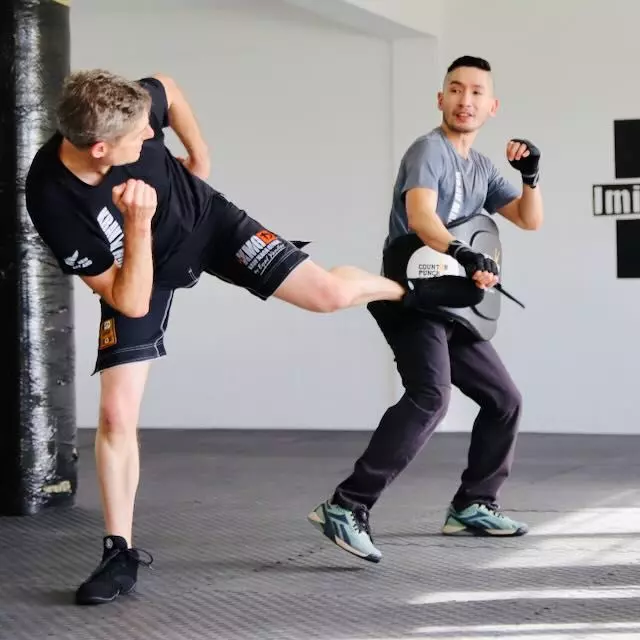 Krav Maga Auckland student practising a side kick against a rubber training knife