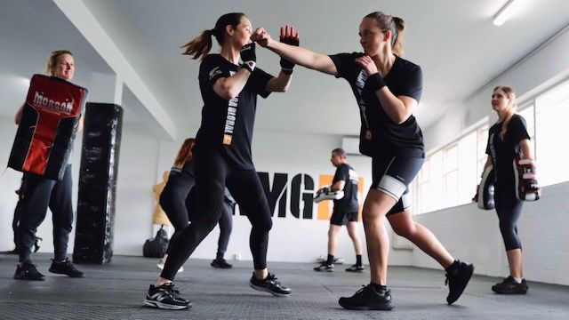 Woman practising defence against a punch during a Krav Maga training class